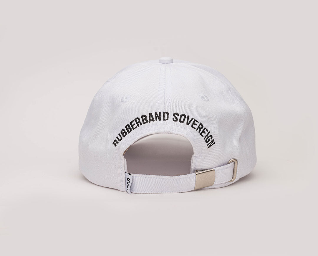 A white coloured, one-size-fits-all 6-panel cap, made of 100% cotton. The back of the cap has the RUBBERBAND SOVEREIGN black embroidery above the opening, and a metal clasp closure  for an adjustable fit. with a low profile unstructured design enhancing its casual, laid-back look.